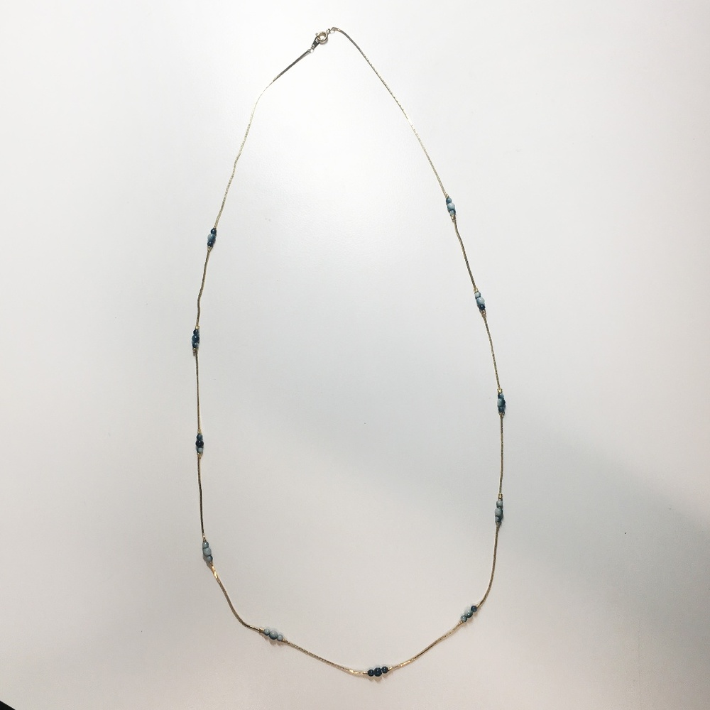 Delicate, gold-tone necklace with blue beads